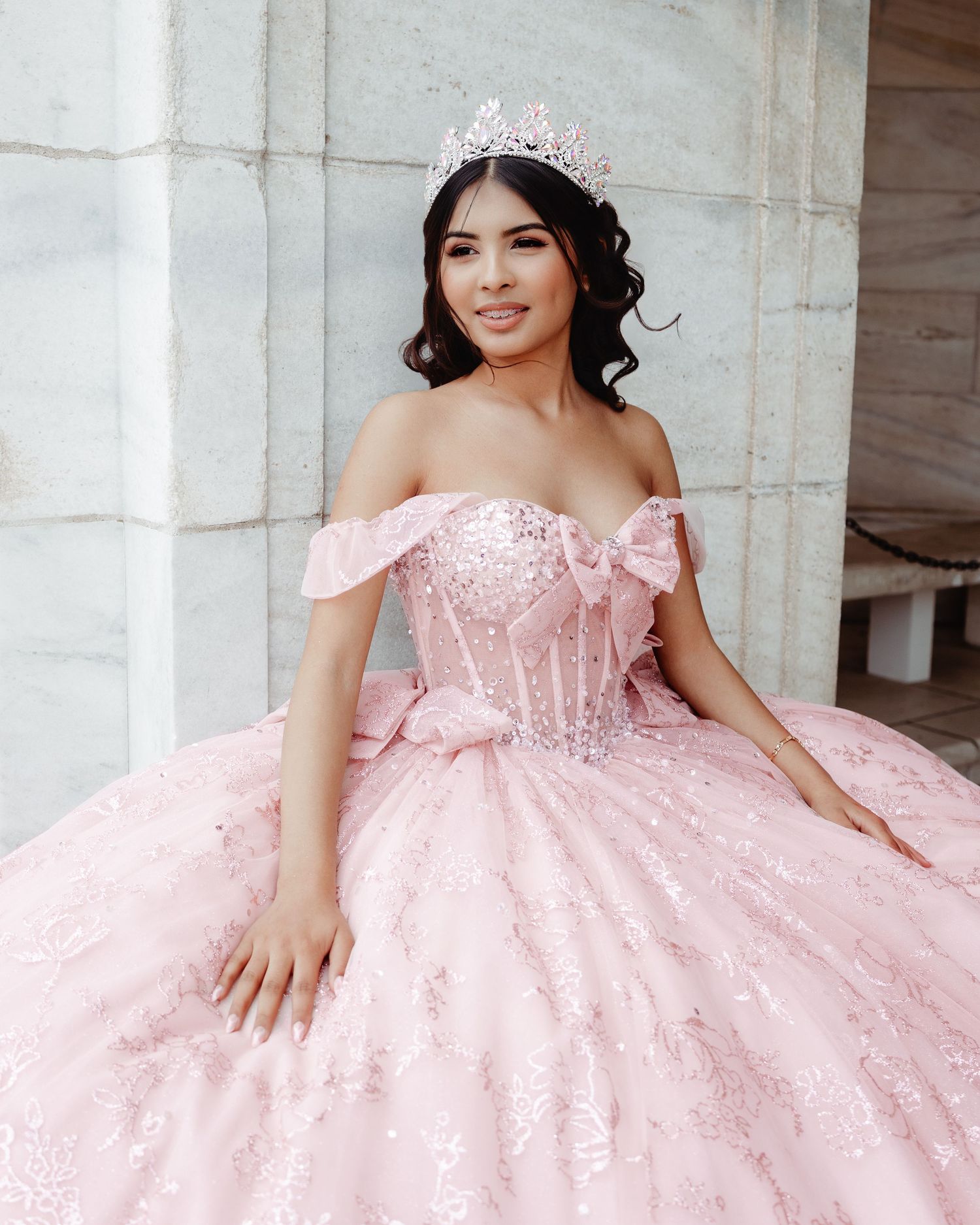 A quinceañera celebration featuring a young woman in a pink ball gown with intricate beading and embellishments.