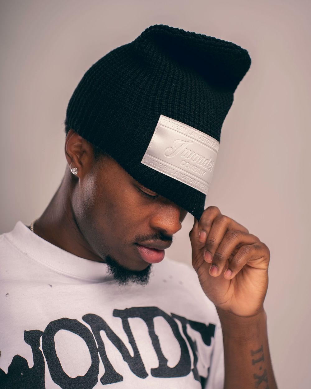 Artistic portrait series showing different angles of someone in a green beanie and white sweatshirt.