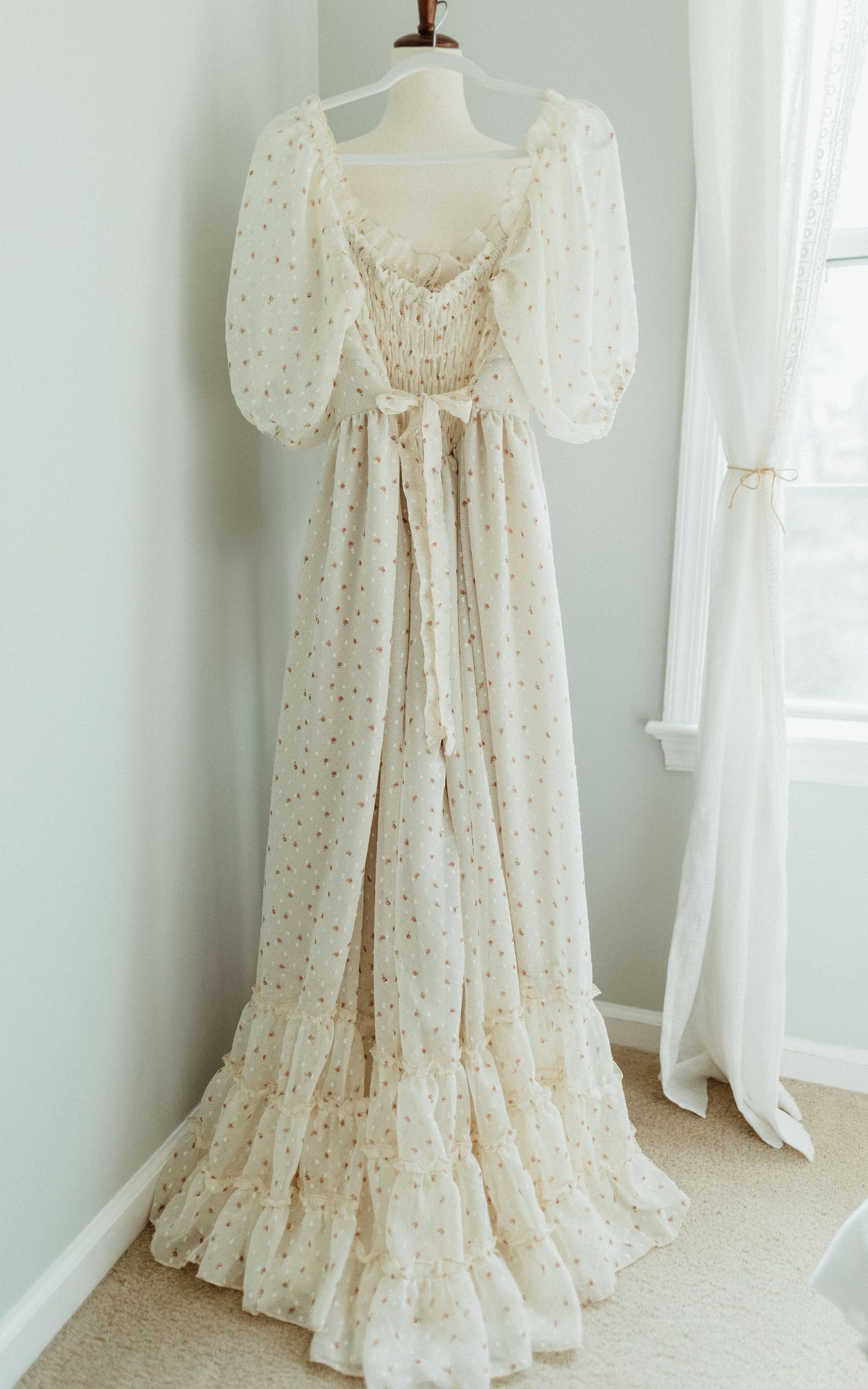 Vintage cream-colored peasant dress with puff sleeves and corset back lacing displayed on mannequin from multiple angles.
