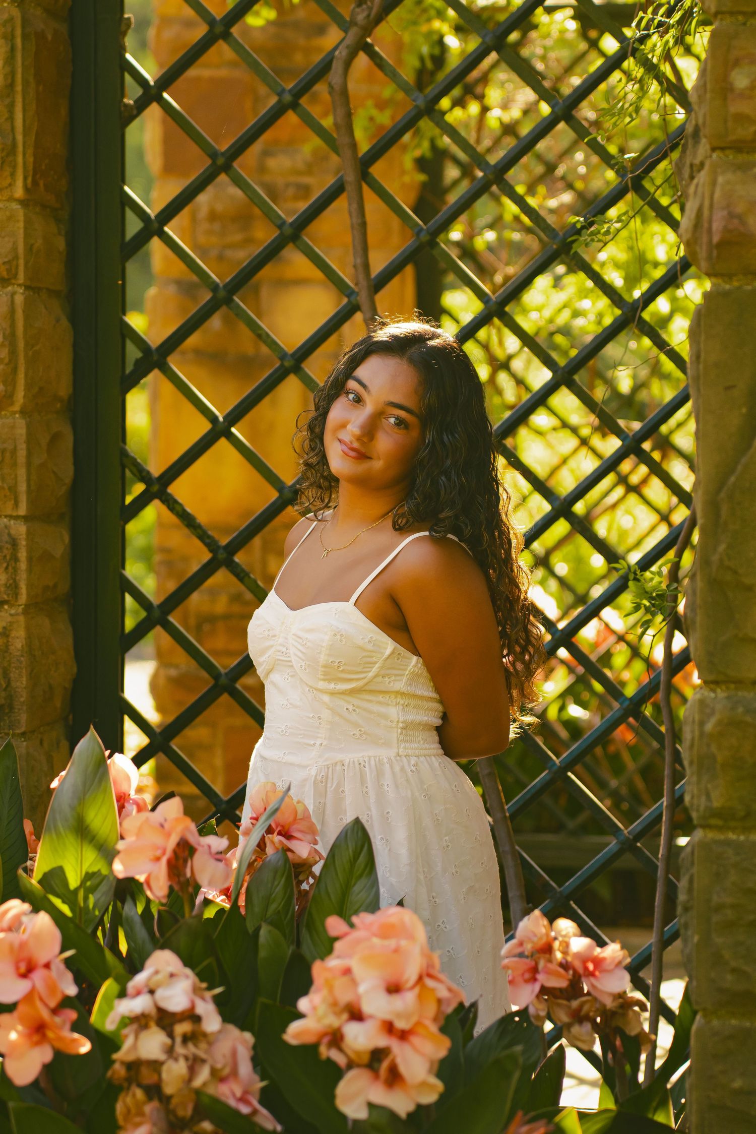 Person in overalls and pink top poses among yellow autumn foliage.