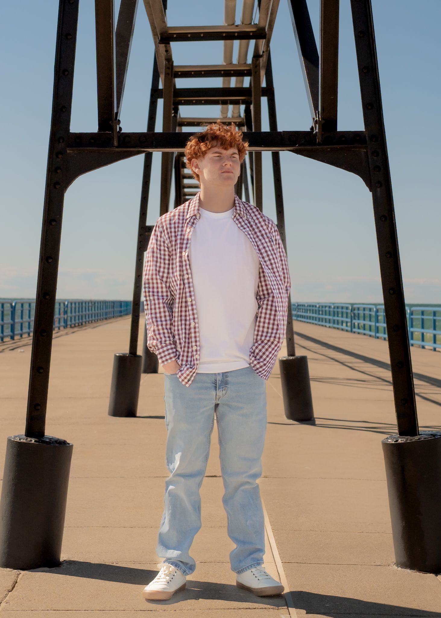 A sequence of photos showing someone in a plaid shirt and jeans standing under a pier structure.