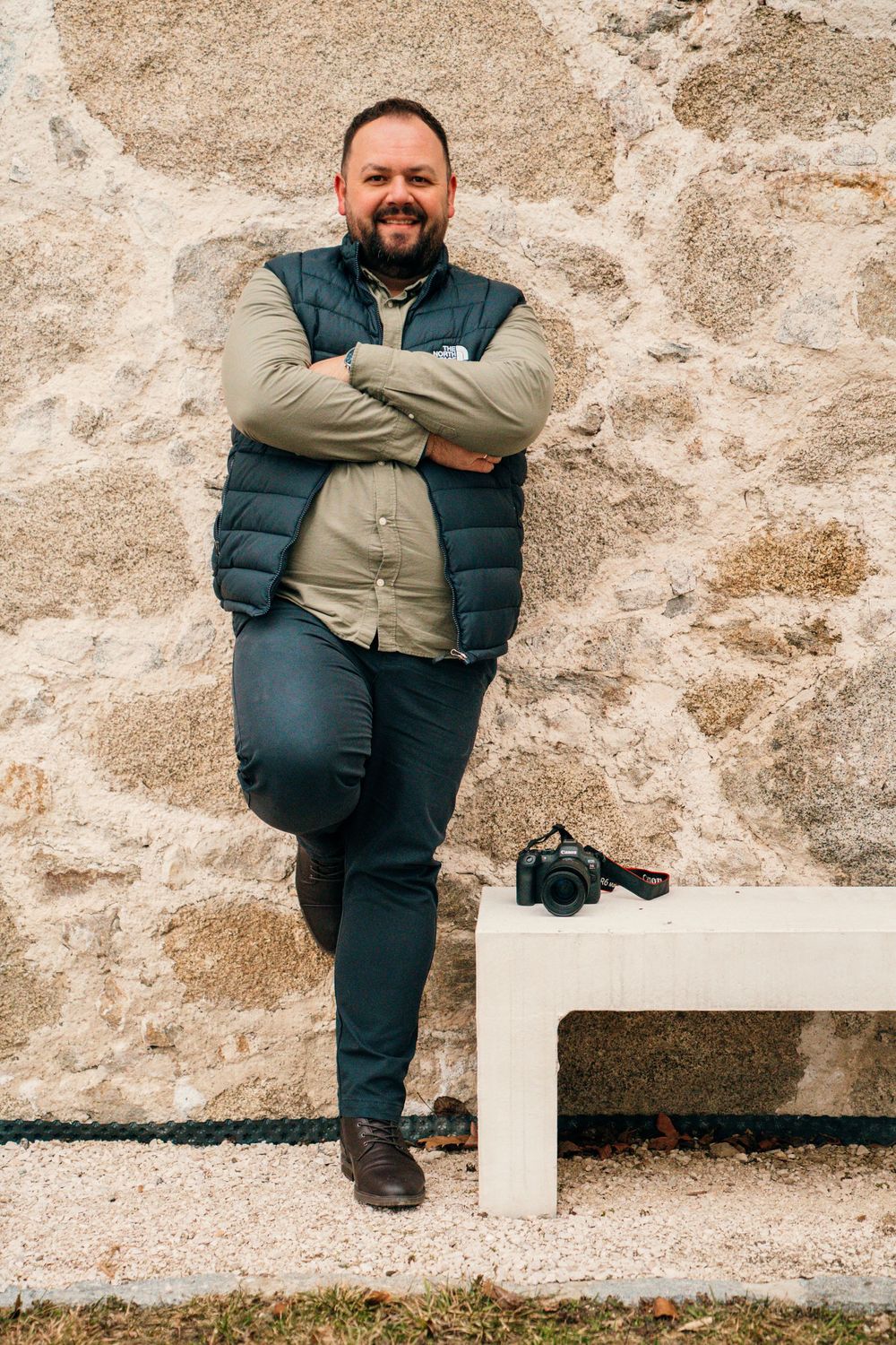 A person in casual attire poses playfully against a textured stone wall in a series of creative portrait shots.