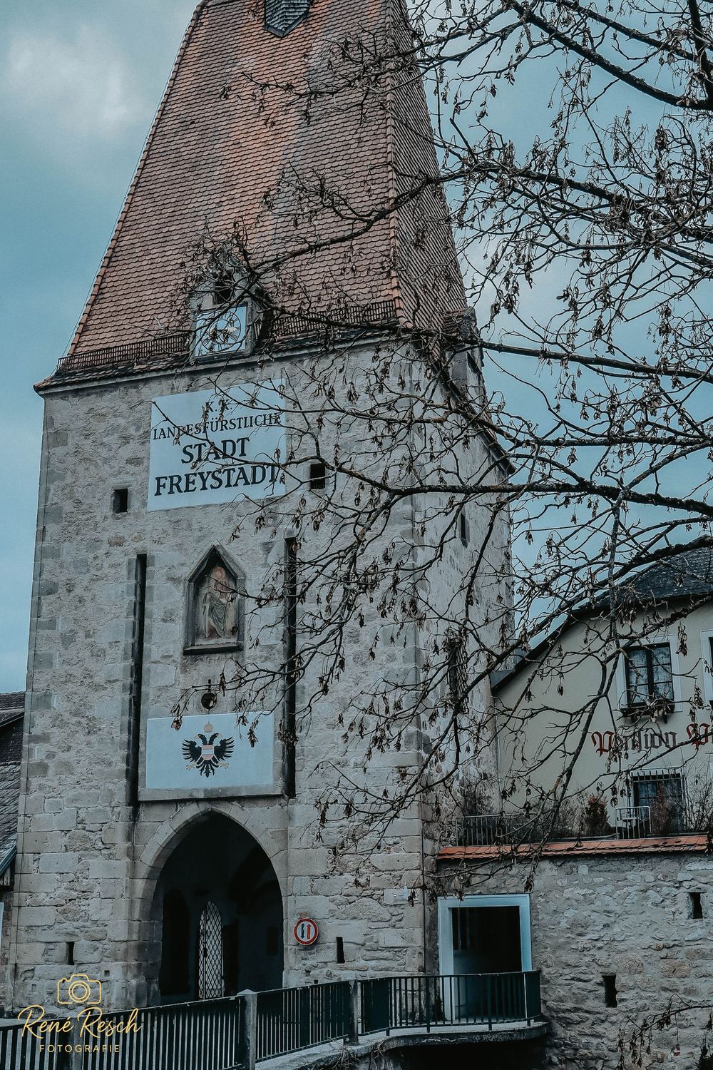 Historic stone church facade with Gothic archway and Freistadt signage.