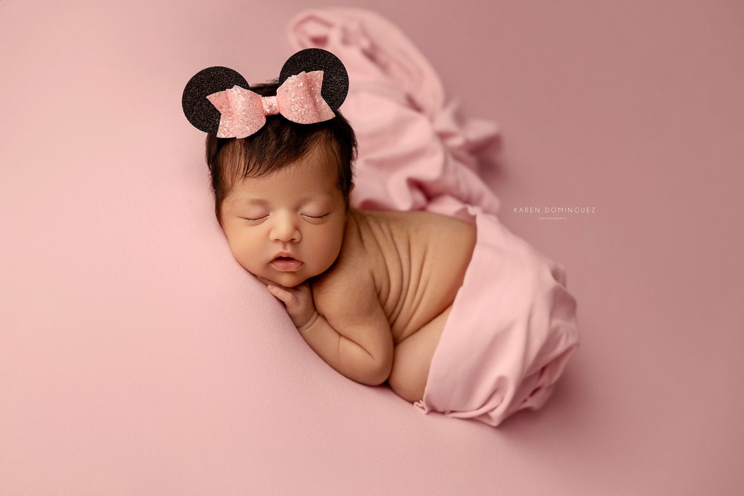 Sleeping newborn baby wrapped in soft pink blanket against pink background in artistic portrait collage.