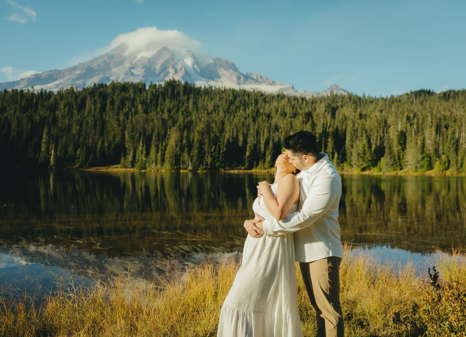 Scenic mountain lake wedding photography series with snow-capped peaks and evergreen forest in the background.