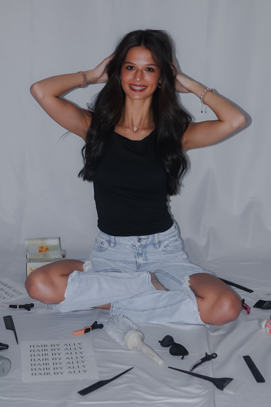 Playful photo series showing someone in a black top and light jeans sitting on the floor with scattered papers.
