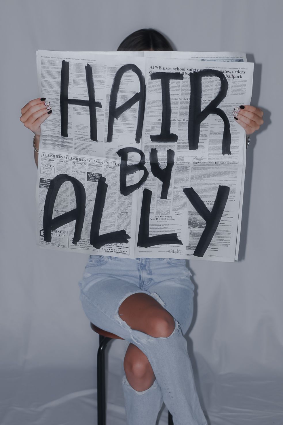 Series showing ripped jeans and text signs being held up against a gray background.