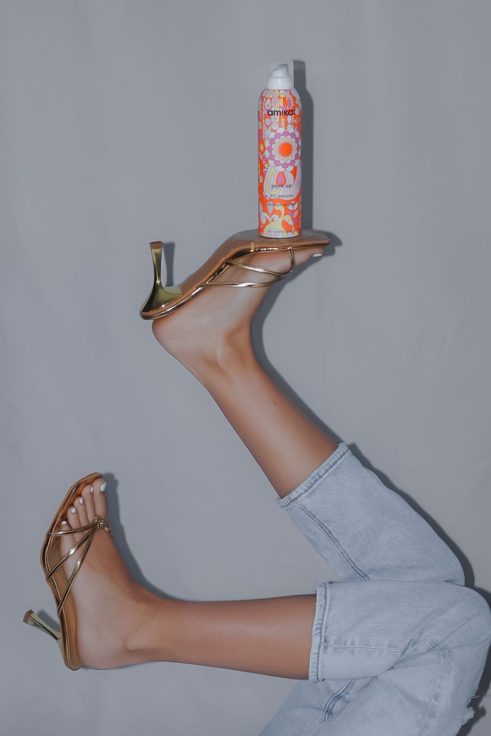 Creative photo series of legs in light jeans balancing soda cans.
