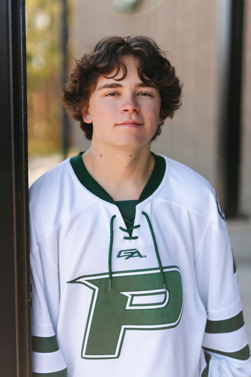A sports portrait wearing a white and green P-logo hockey jersey.