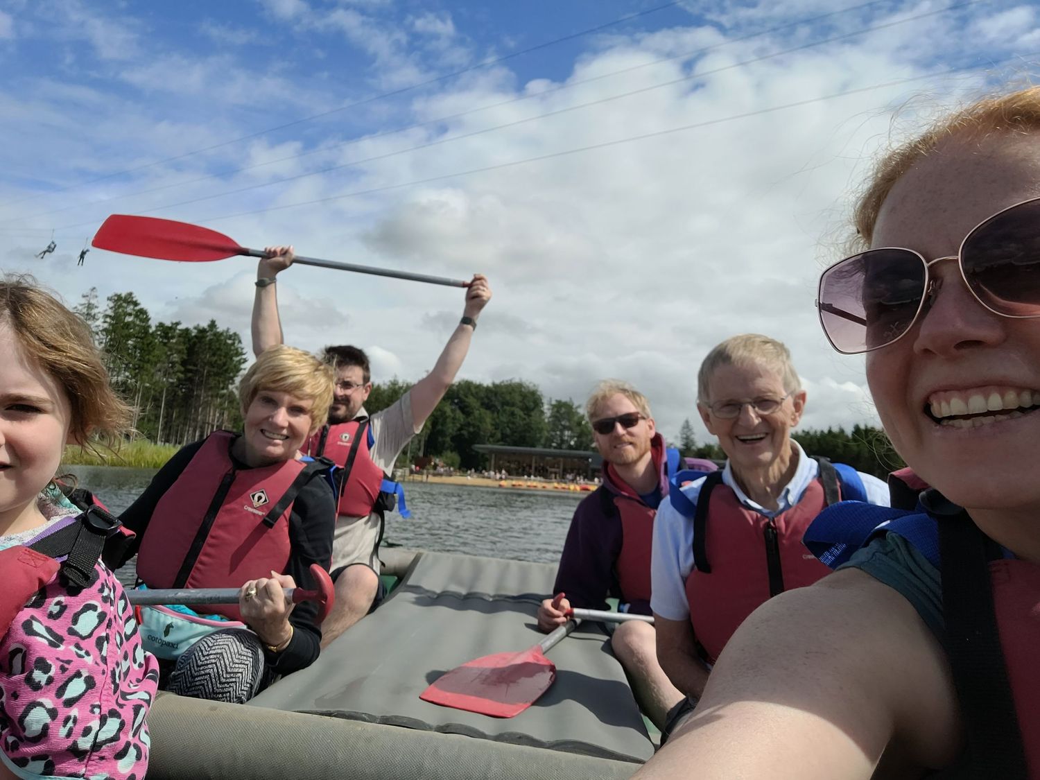 Group enjoying a boat ride on a sunny day with blue skies and scenic views.