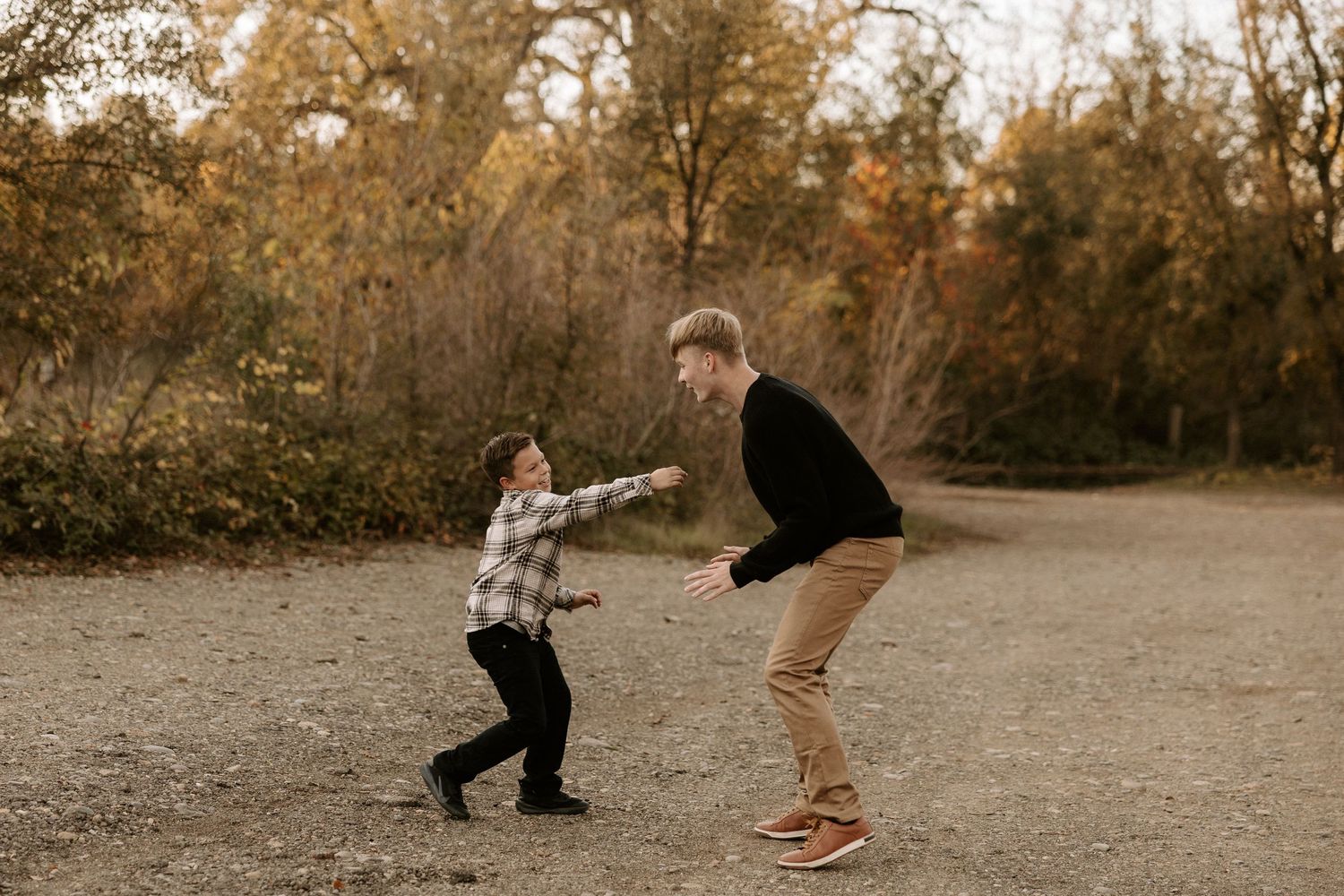 A sequence of seven sepia-toned photos showing a playful dance between two people in an autumn field at sunset.