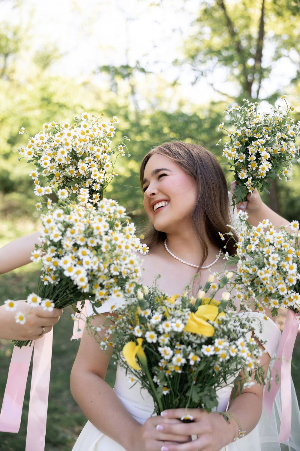 A joyful moment captured with white daisies and pink ribbons in an outdoor garden setting.