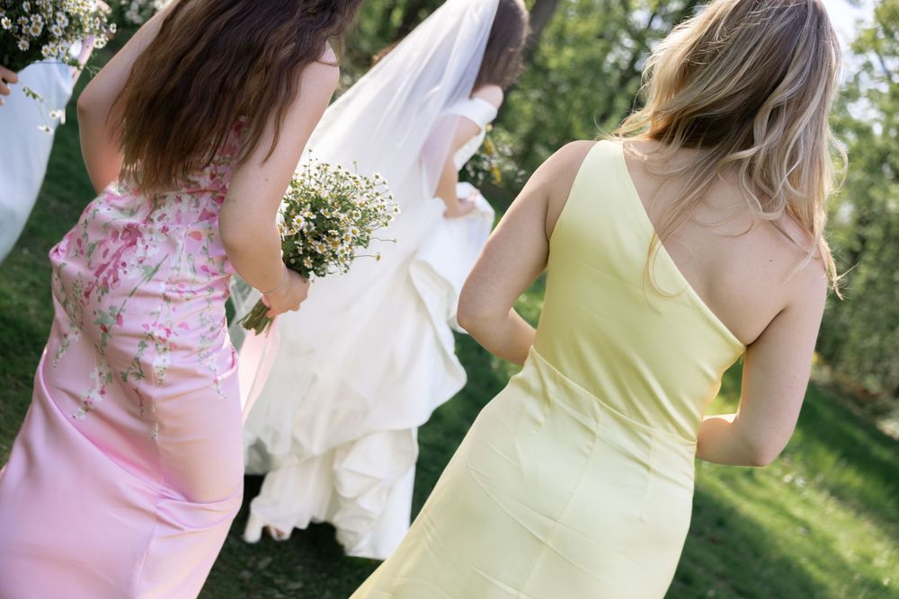 Children playing together in a garden setting wearing pastel colored dresses and floral outfits.