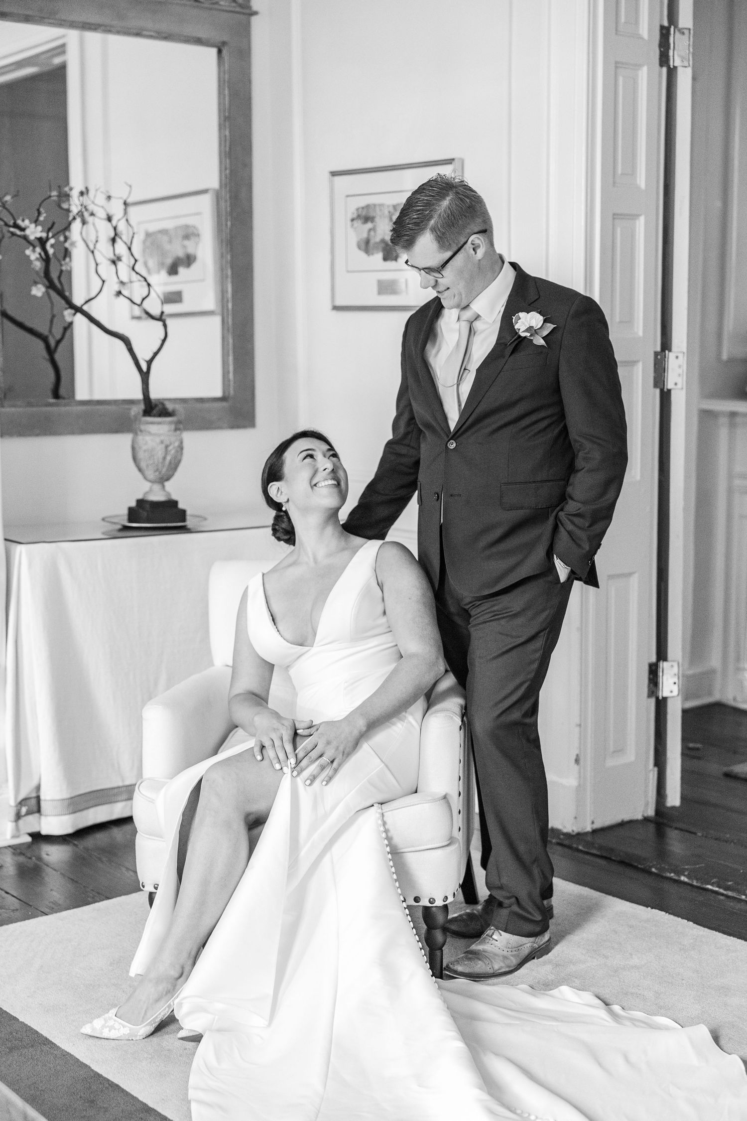 A series of four romantic black and white wedding photos showing a couple in formal attire posing together.
