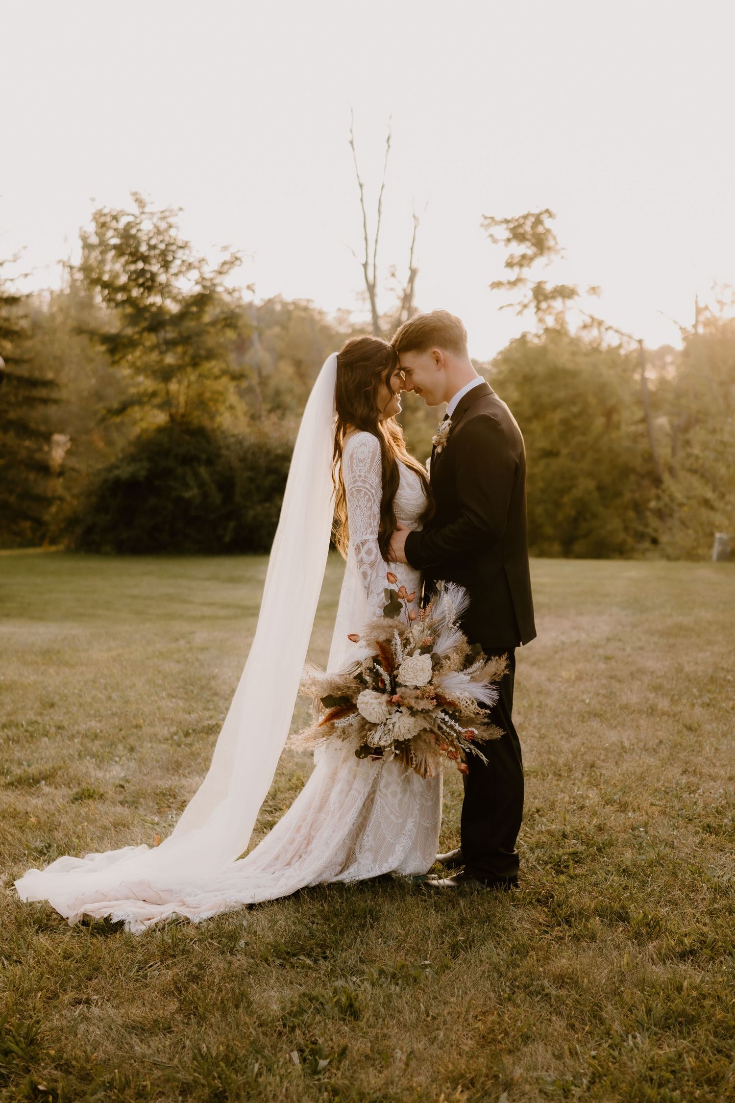 Indiana Wedding and Elopement Photographer // Outdoor wedding portrait with dried floral bouquet and flowing veil in golden light.