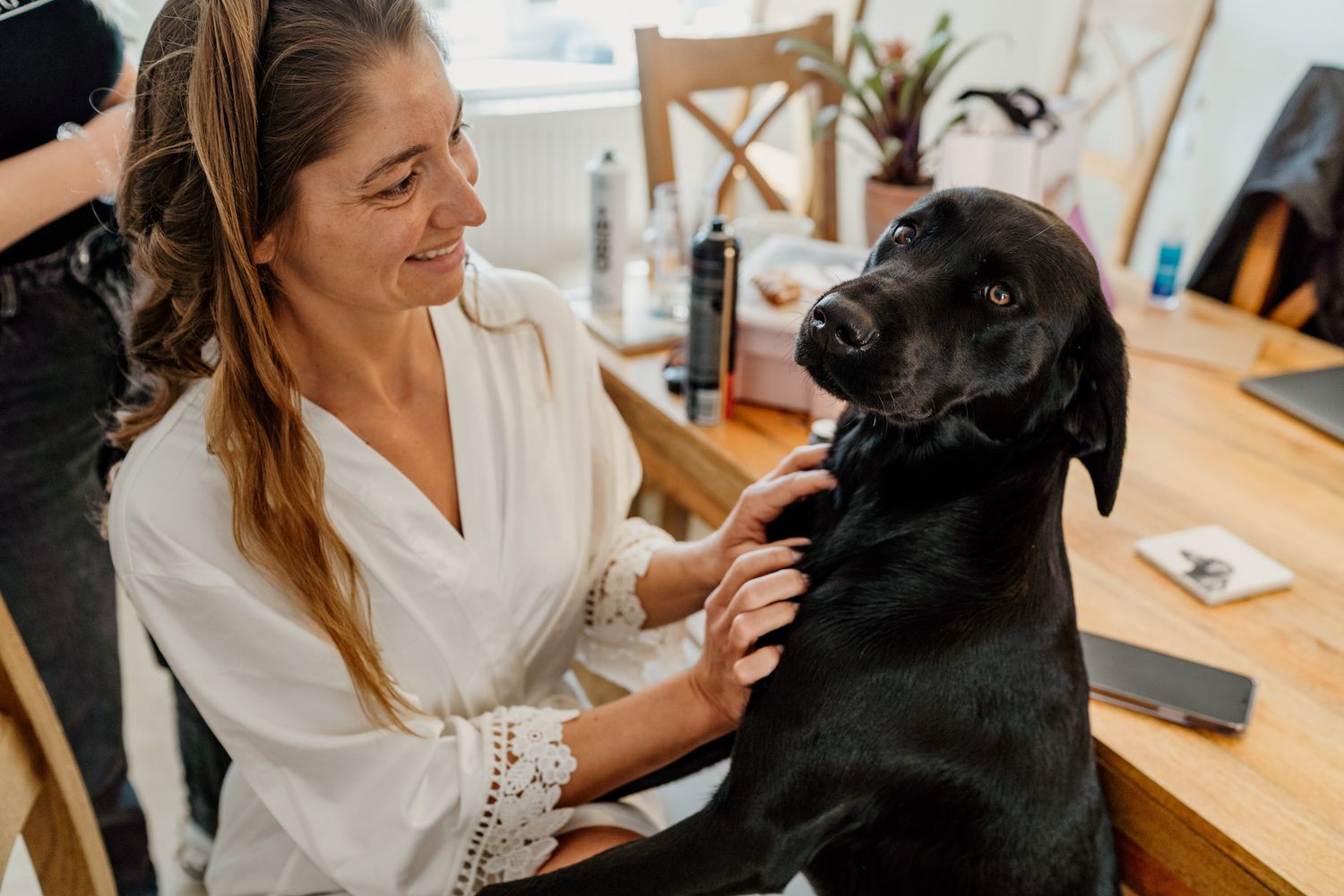 Black dog receiving affectionate pets and attention.