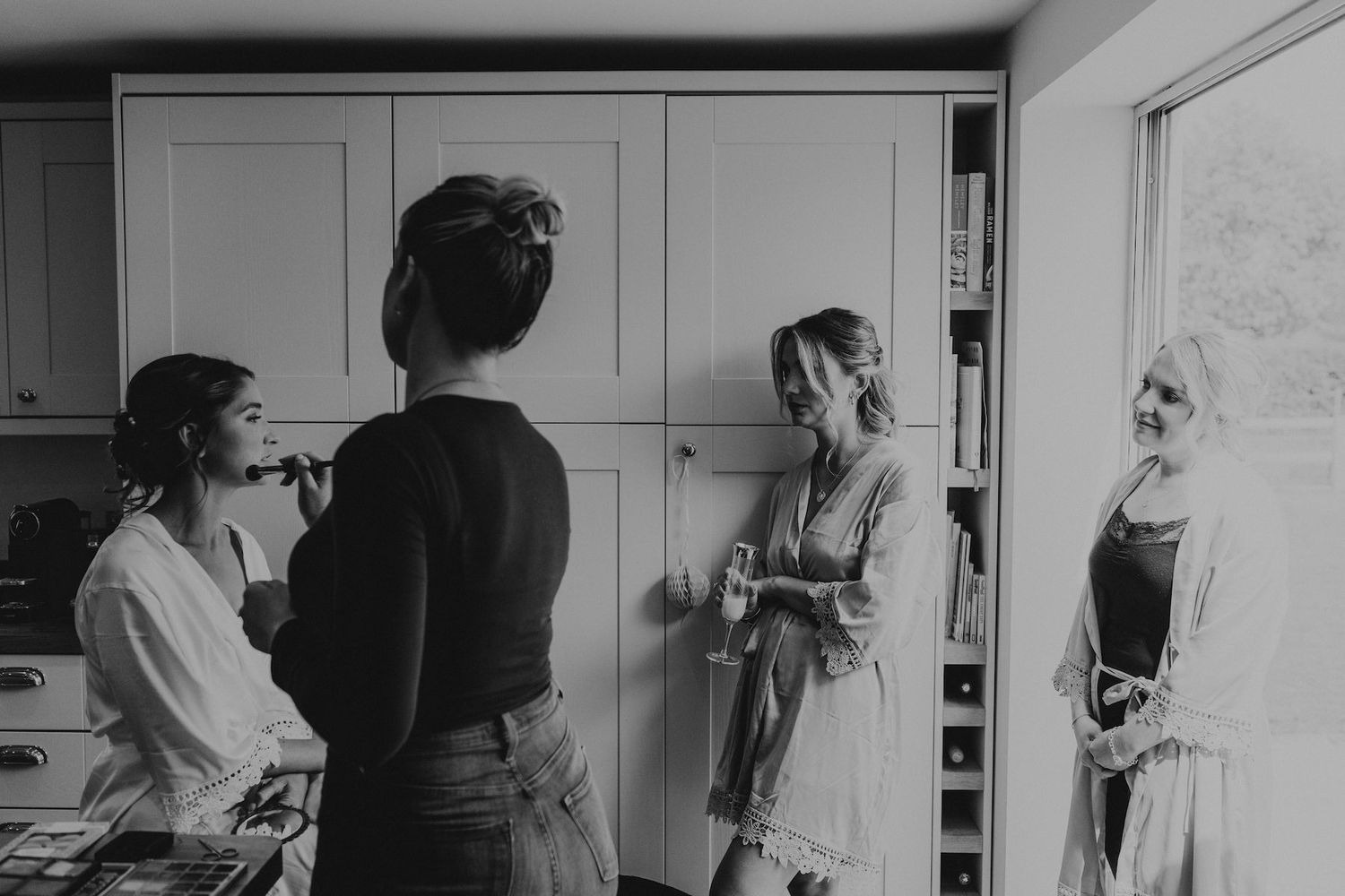 Black and white candid shots of wedding preparation moments in an intimate indoor setting.