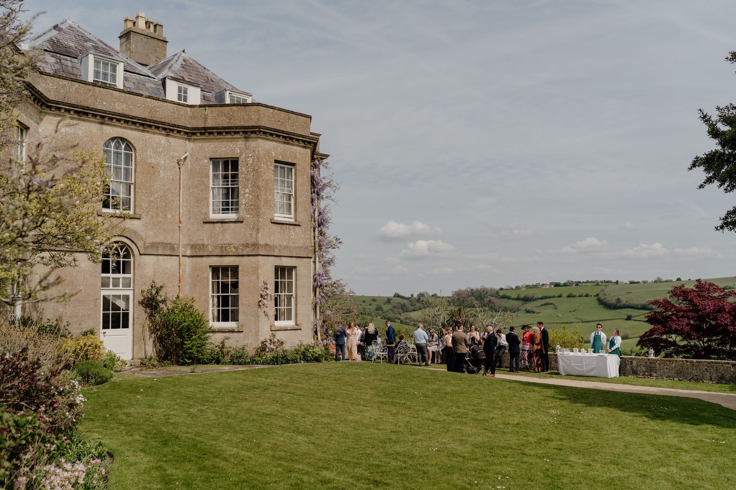 Panoramic view of a grand country estate with manicured lawns and classic architecture.