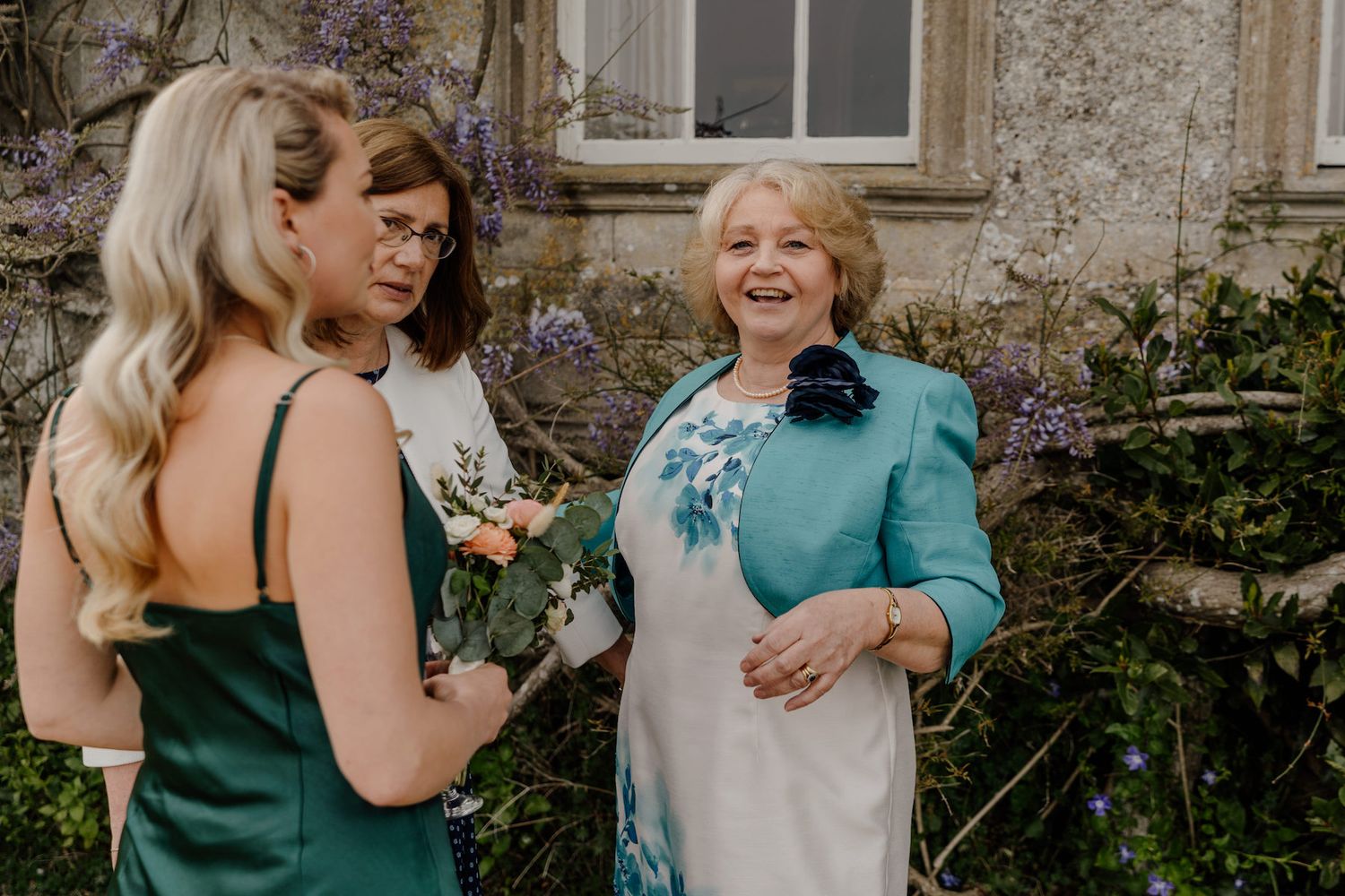 Two guests share a joyful moment outdoors during an elegant wedding celebration.