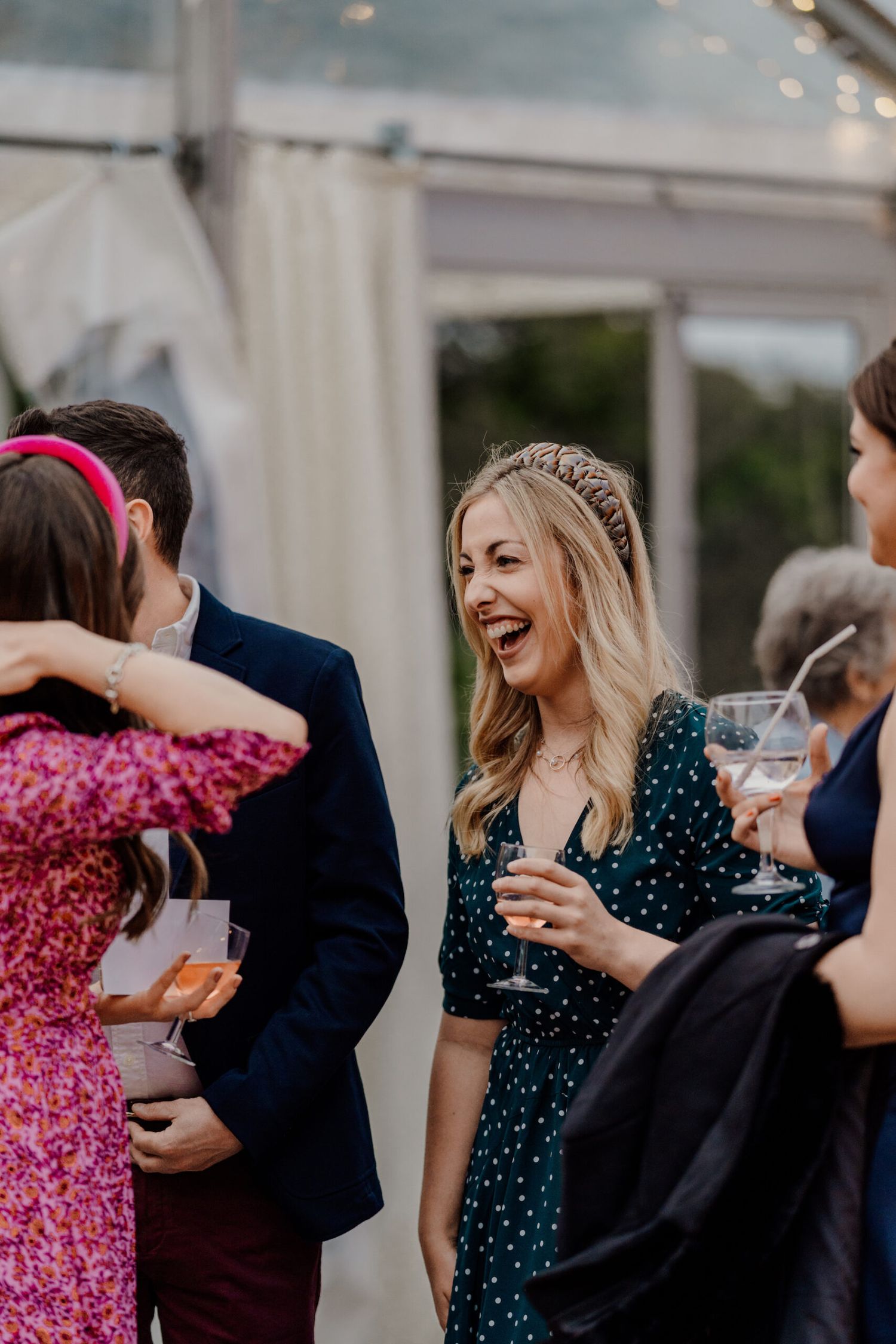 Wedding guests enjoying conversation and drinks during an outdoor reception.