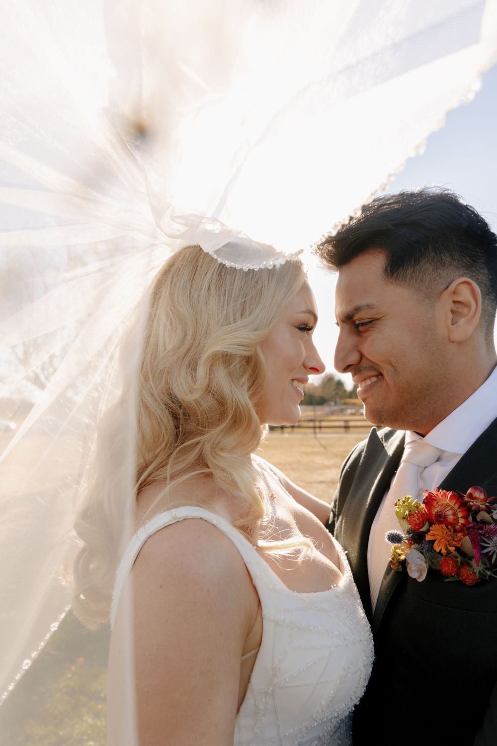 Romantic wedding couple shares intimate moments during golden hour sunset photoshoot in a dreamy outdoor setting.