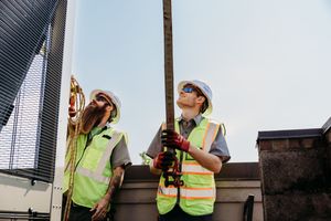 Worker in safety vest and helmet takes a drink break at a construction site with multiple similar views shown in sequence.