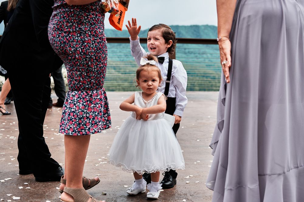 Flowered bridesmaid dresses and formal attire at a seaside wedding ceremony with blue ocean views.