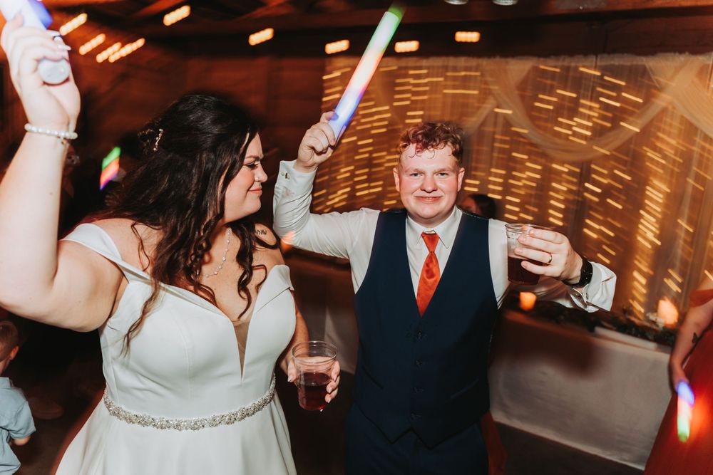Wedding reception celebration with dancing and festive lighting.