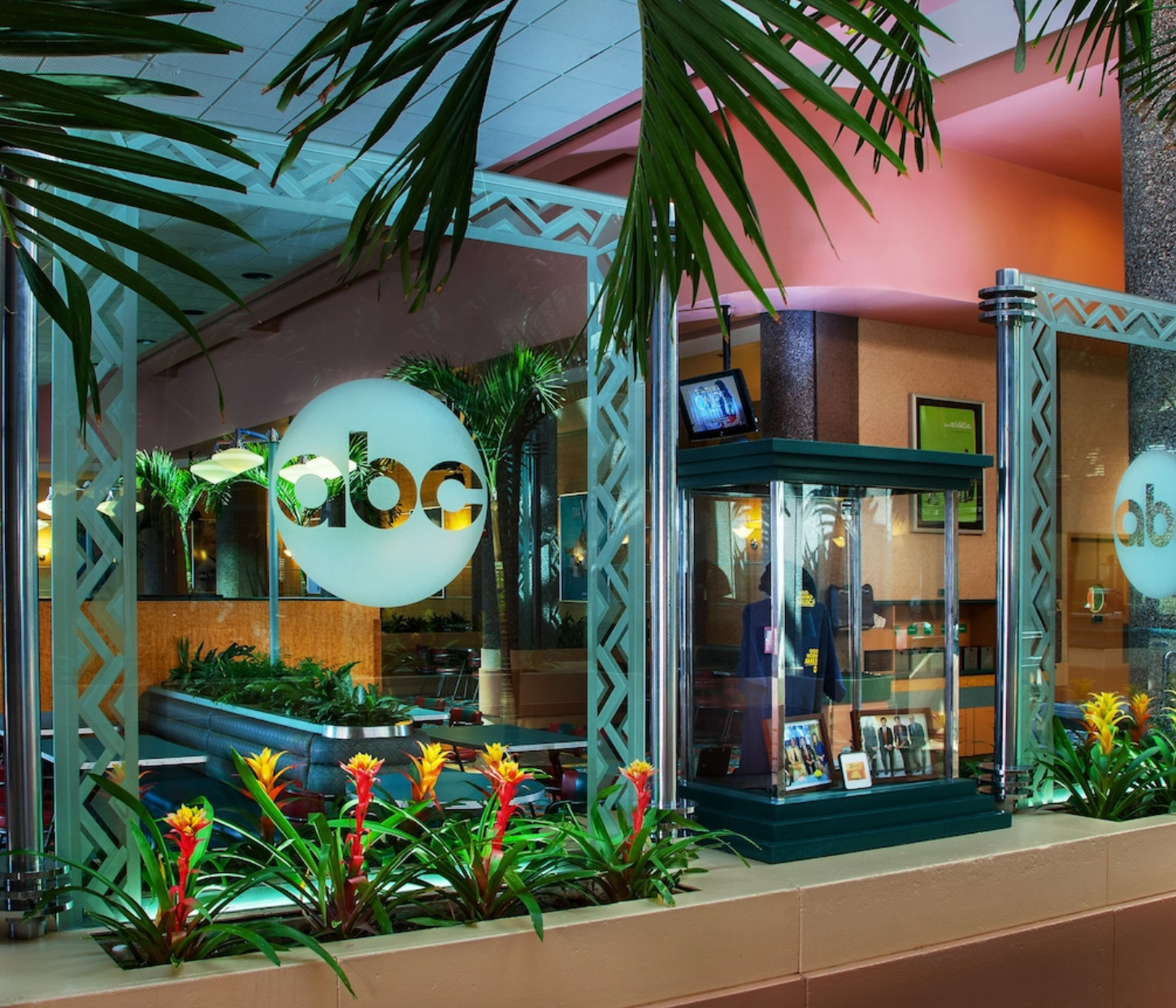 Disney store entrance with tropical landscaping and illuminated signage.