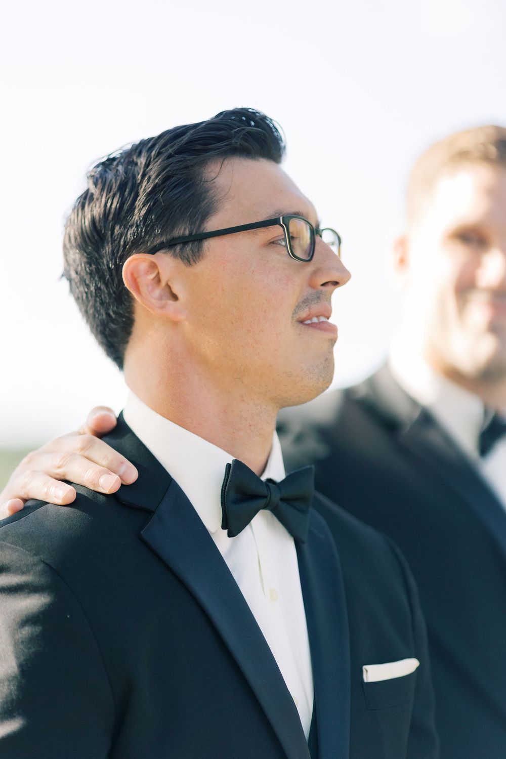 Smiling groomsman in black tuxedo and glasses shown with multiple portrait angles at a formal wedding event.