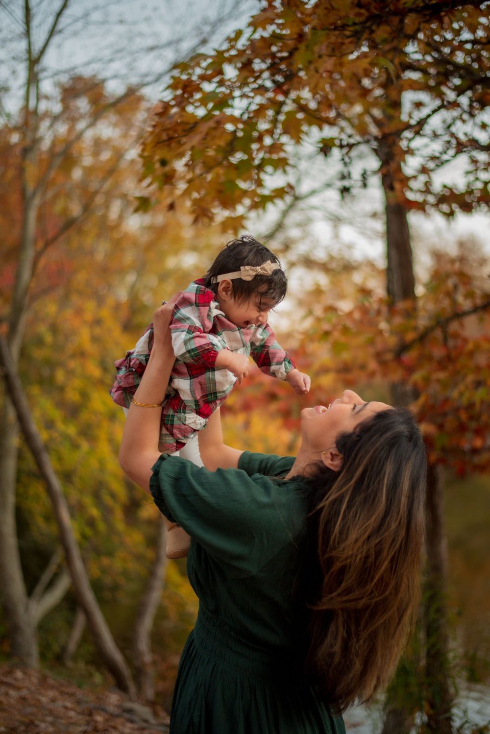 Mother holding baby outdoors in the fall