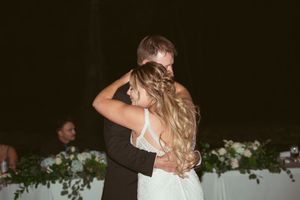 Couple enjoying their first dance as newlyweds under romantic lighting.