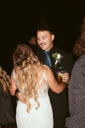 Guests dancing and celebrating on a dimly lit dance floor at a wedding reception.