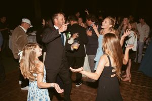 Multiple couples dancing together at a lively nighttime wedding celebration.