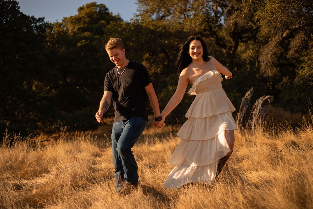 Couple walking through sun-drenched field during their outdoor photo session.