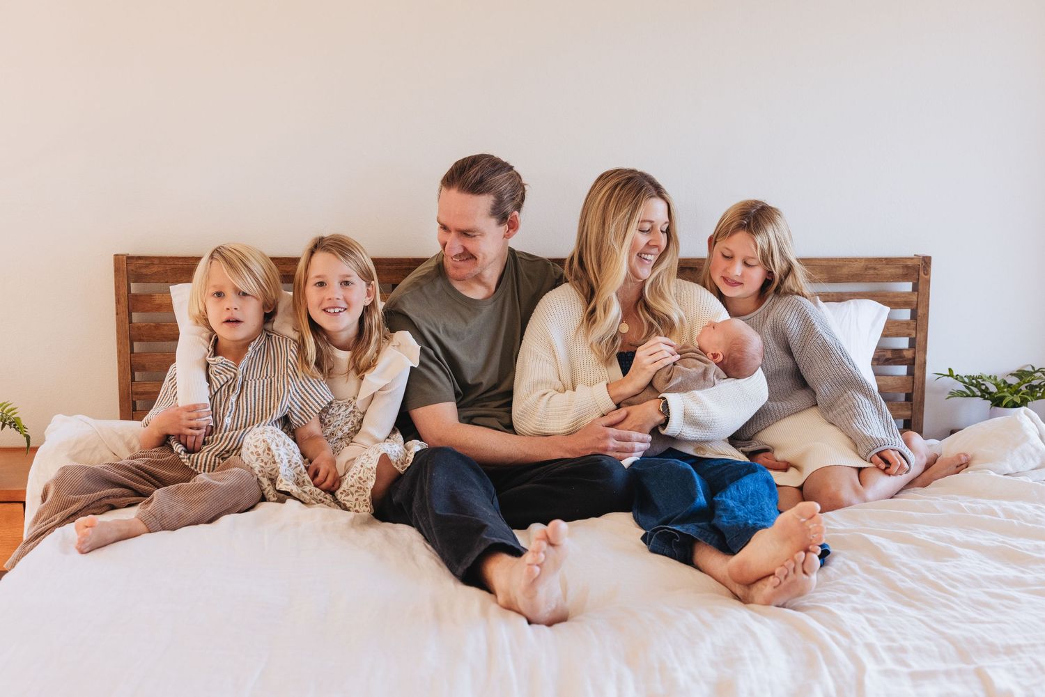 New parents tenderly holding their sleeping newborn baby in a bright nursery room.