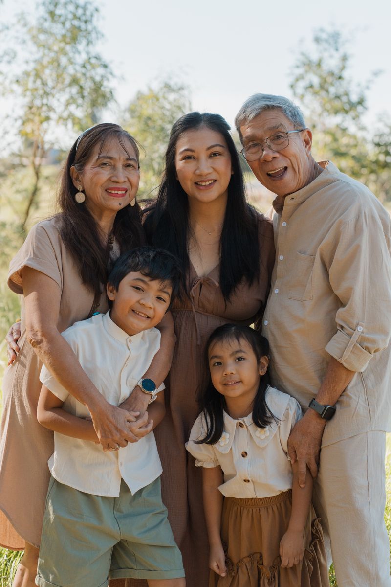 Three-generation family smiling together, grandparents posing with adult daughter and two young children during family photoshoot in sydney