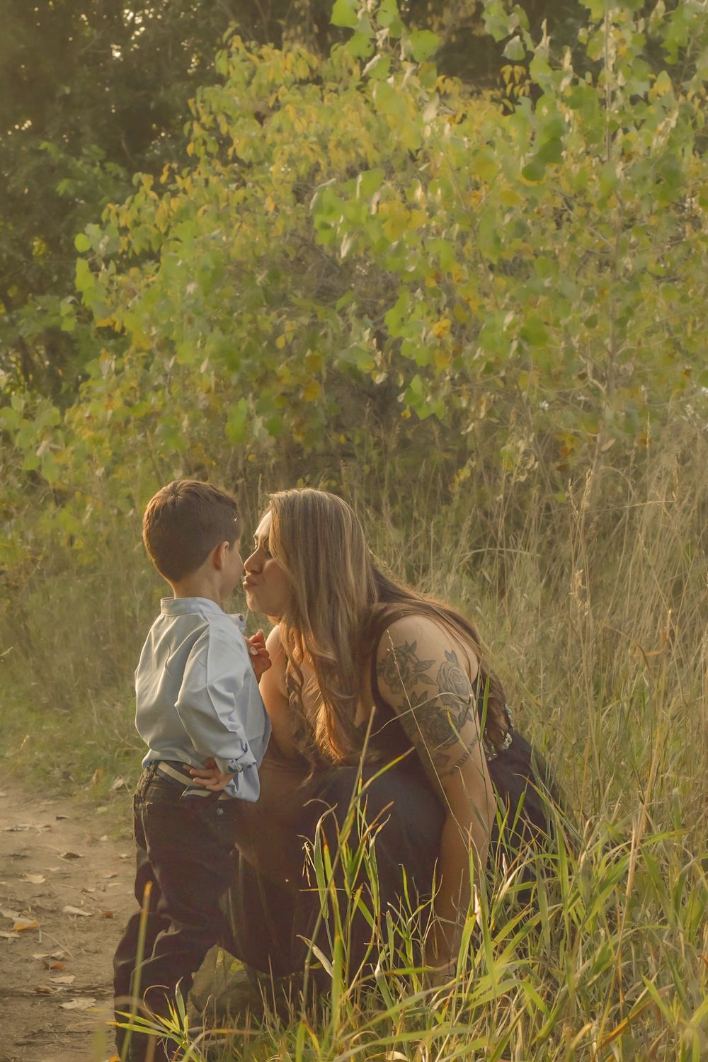 Candid outdoor family moment captured in natural setting with autumn foliage.