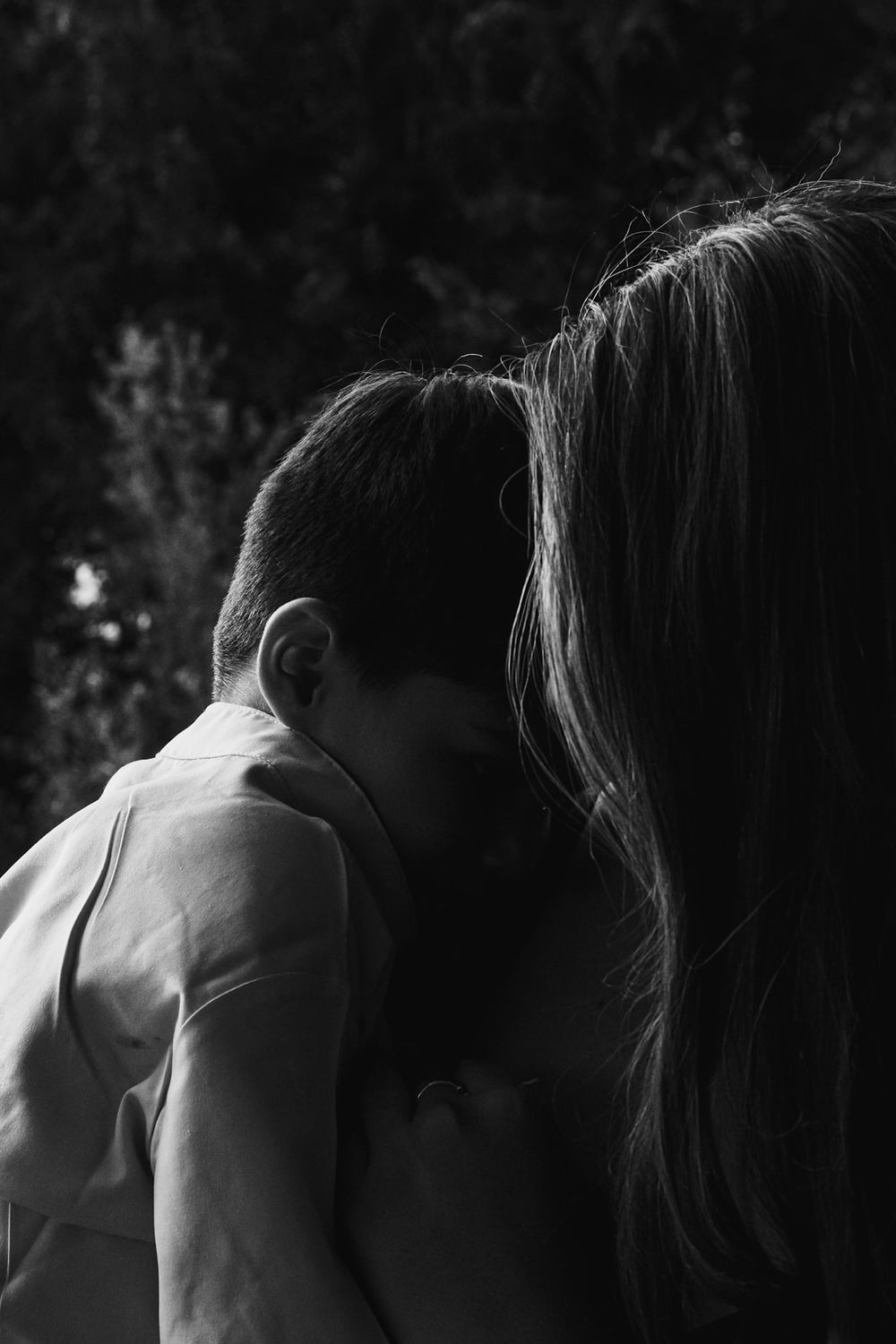 Silhouette of two people embracing in an intimate black and white portrait.
