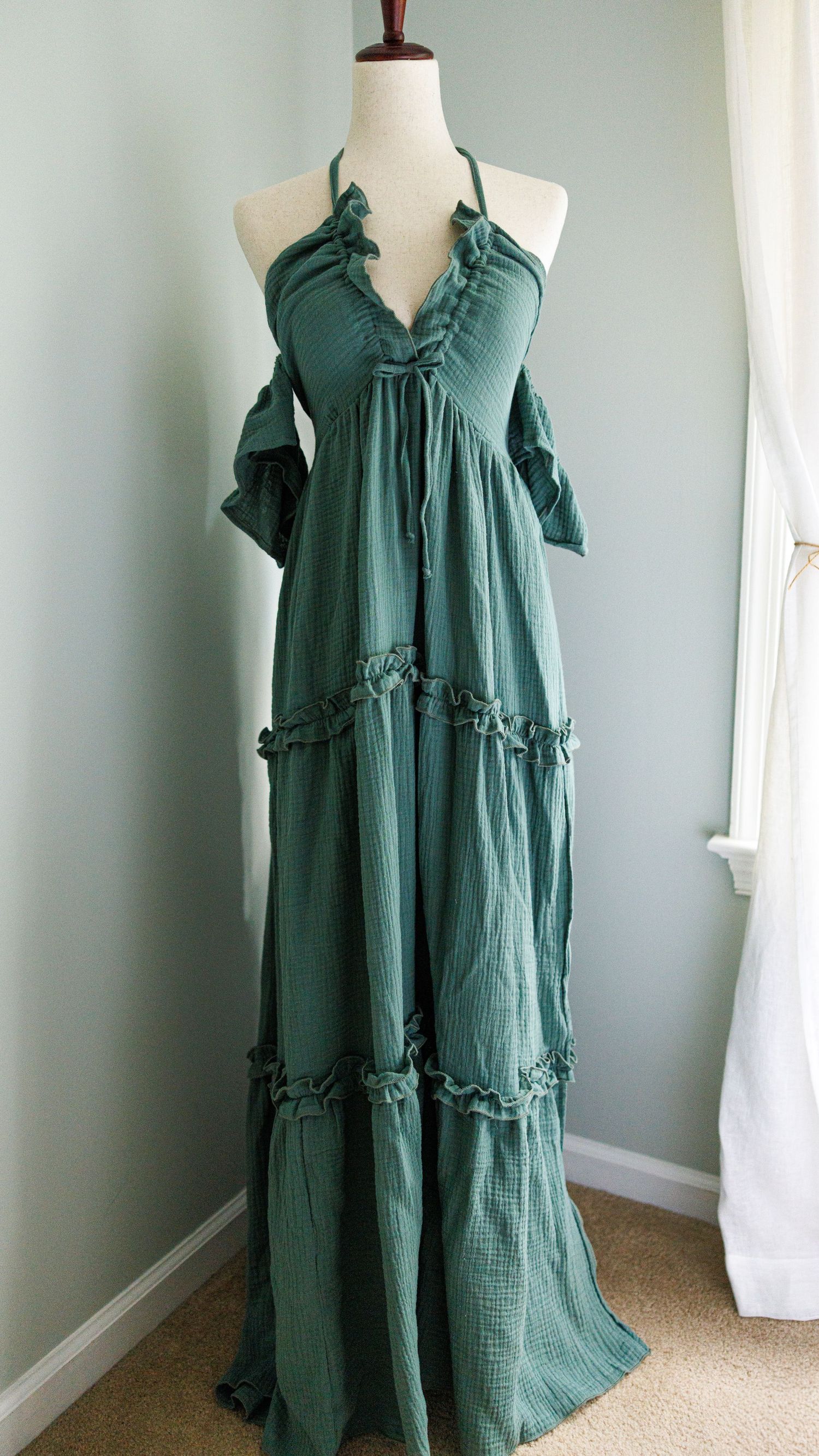 Three views of a flowy green cotton dress with ruffled tiers and short sleeves displayed on a mannequin.