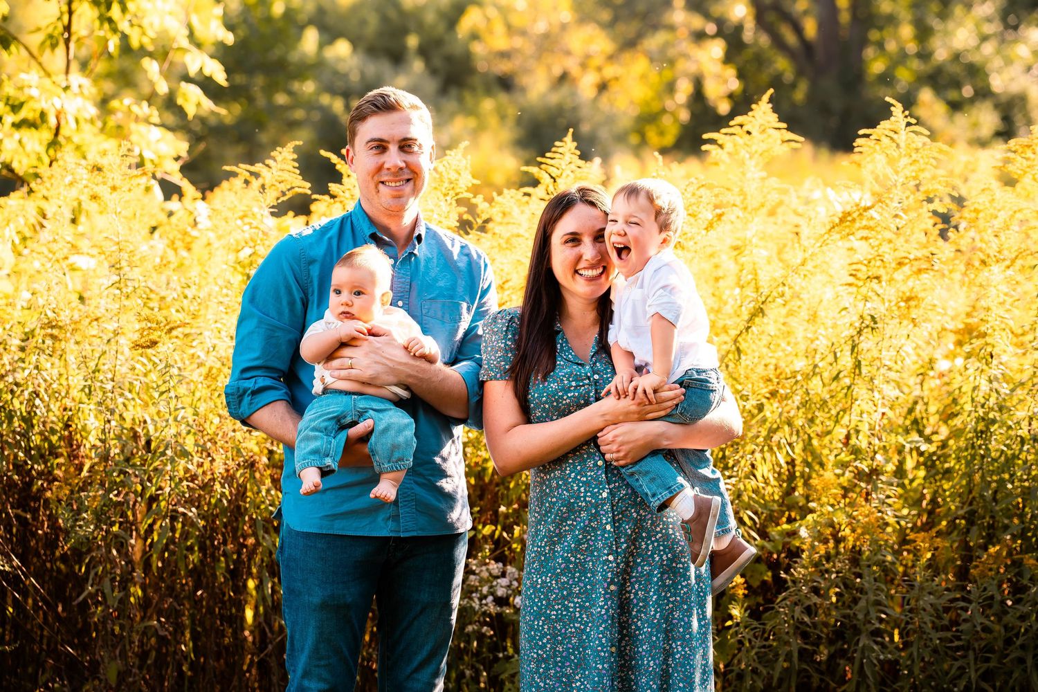 Family portrait series captured in golden sunlight against tall grass.