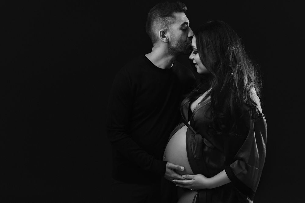 Intimate black and white maternity photos with dramatic shadows and lighting.