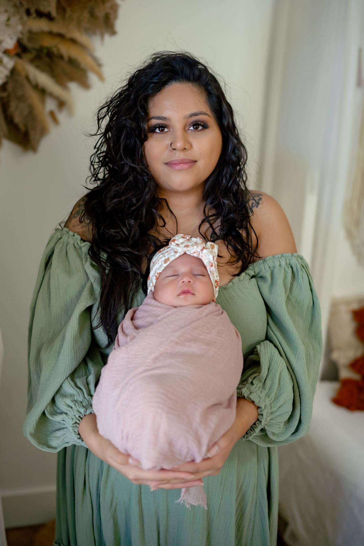 A series of five intimate portraits showing a woman in a sage green top holding a sleeping newborn wrapped in pink.