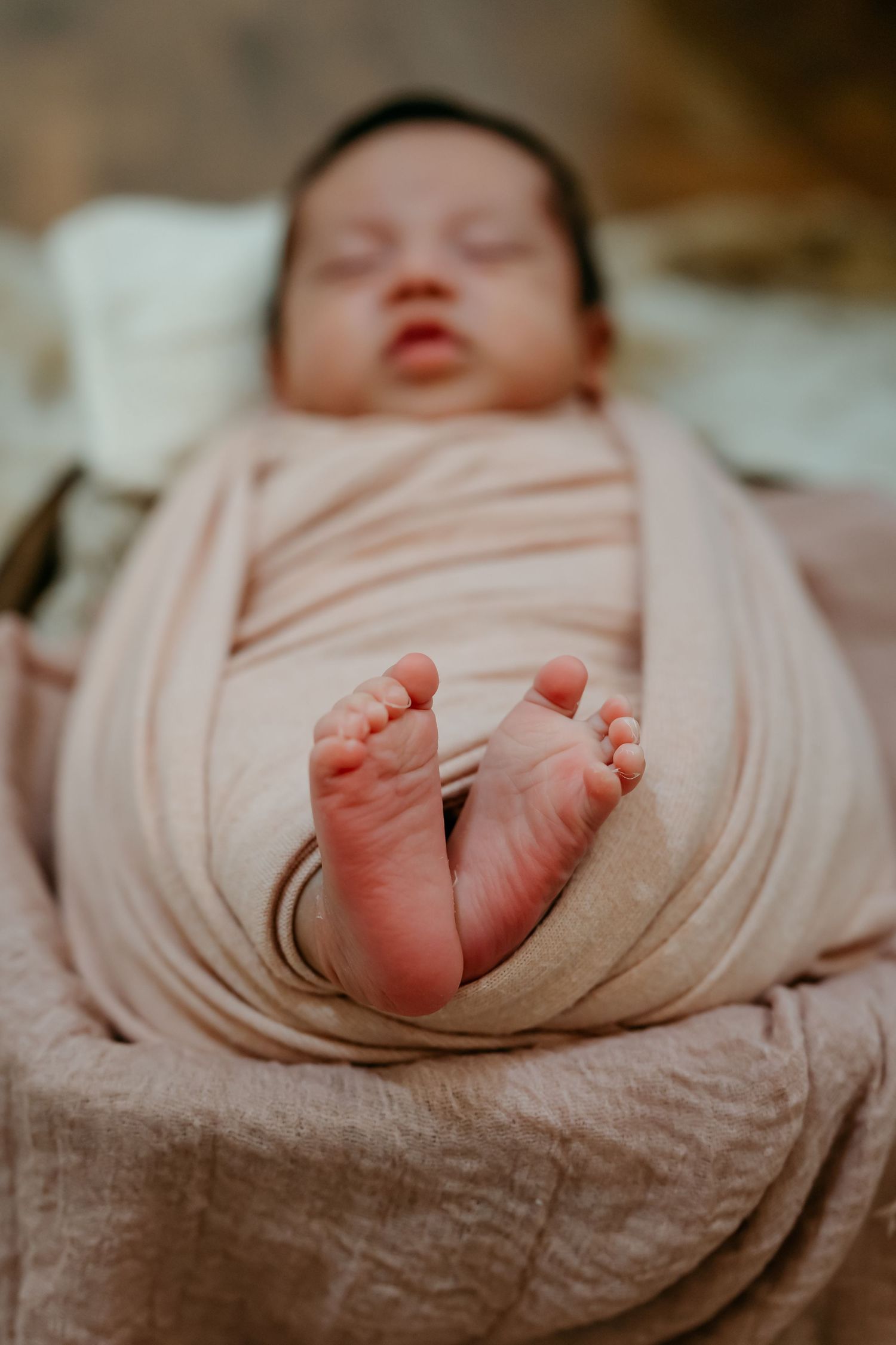 Tiny newborn baby feet wrapped in soft pink blanket shown in series of close-up photos.