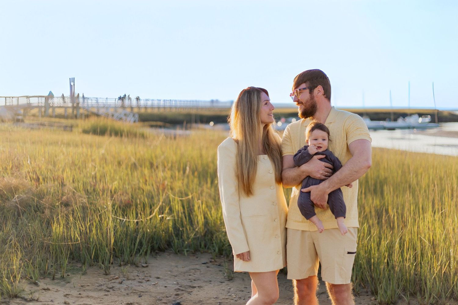 A romantic engagement photo session in a golden marsh field during sunset.