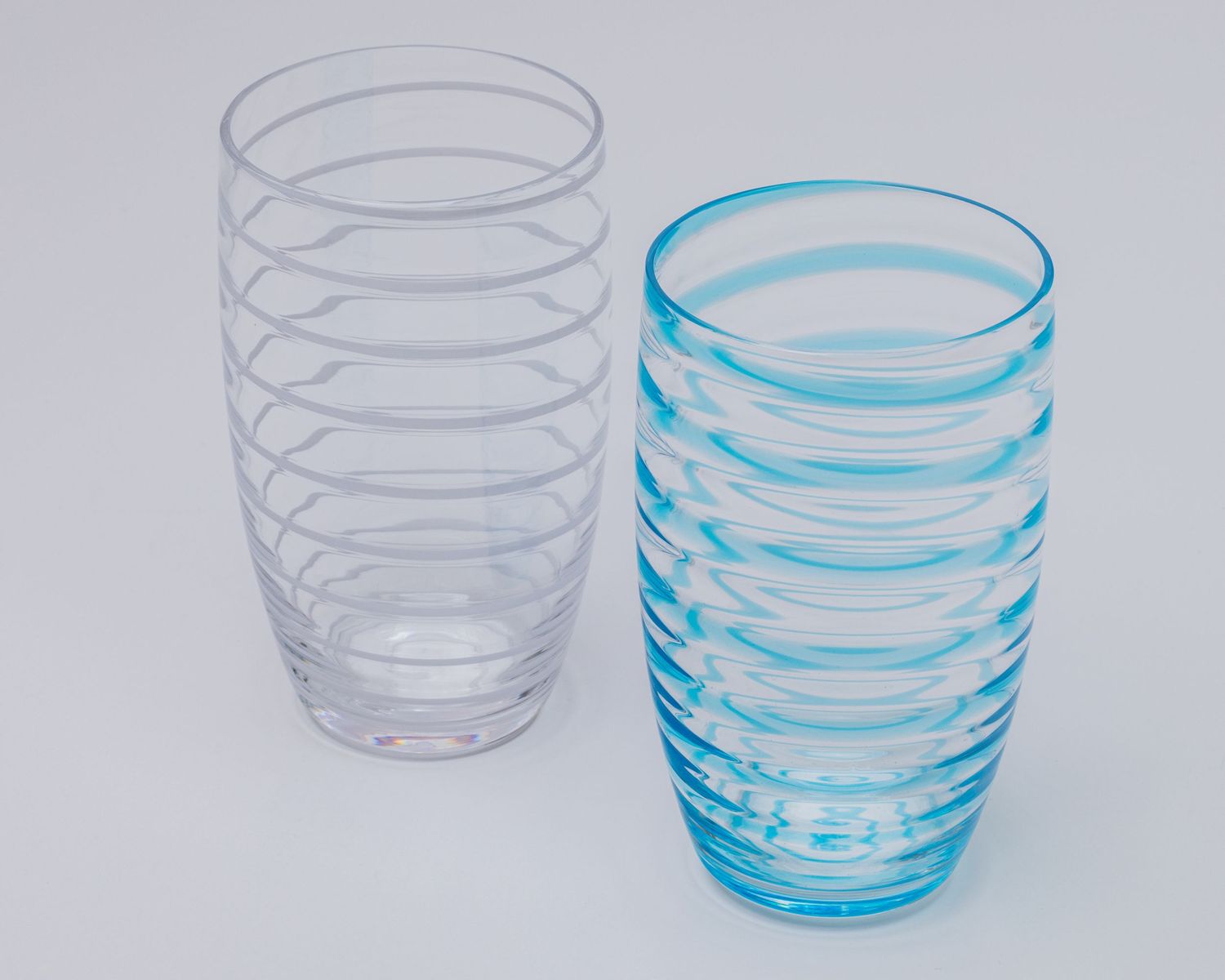 Progressive sequence showing a glass tumbler transforming from plain to decorative blue spiral pattern design.