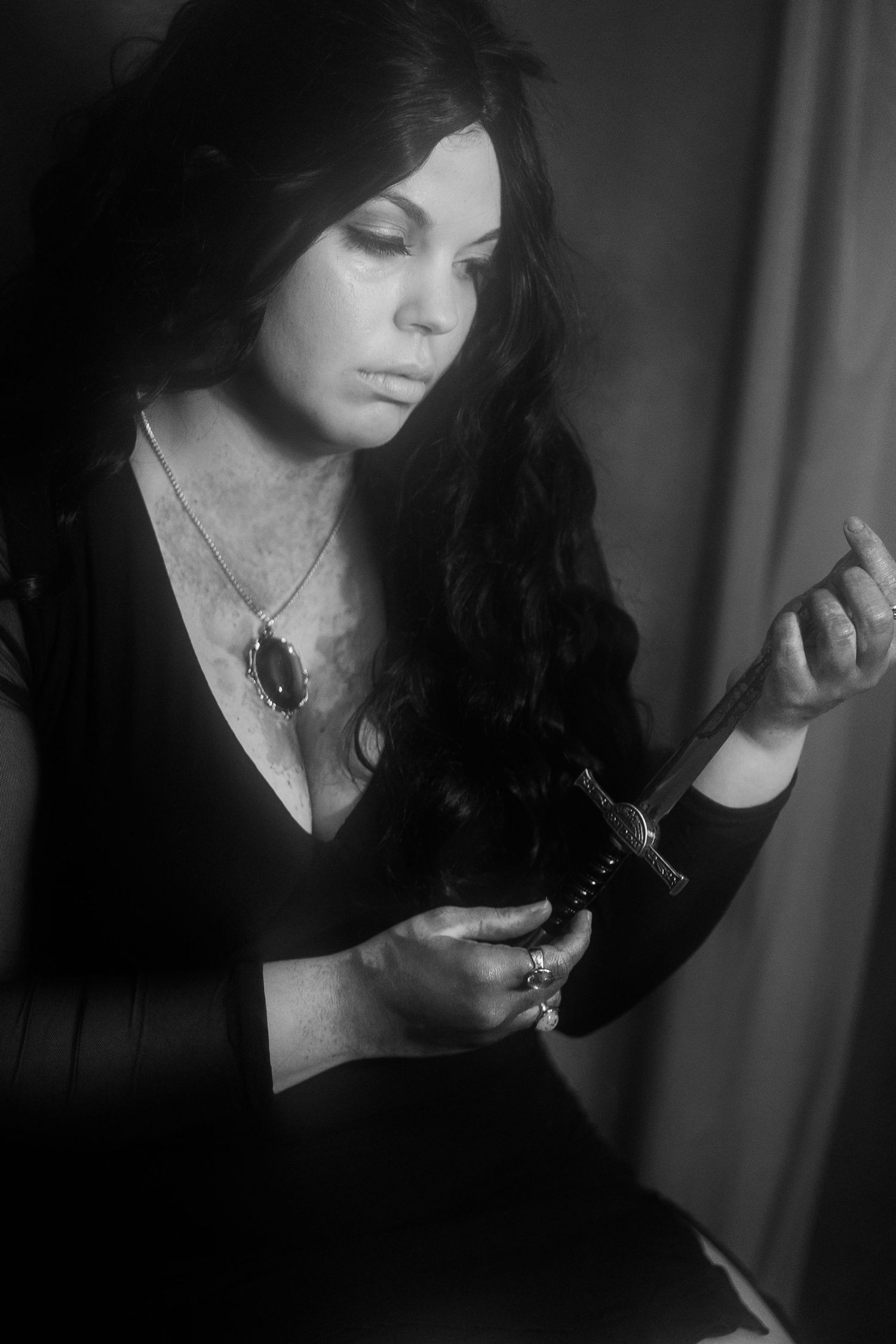 Dramatic black and white portrait series showing a woman in dark clothing holding a cigarette in moody lighting.