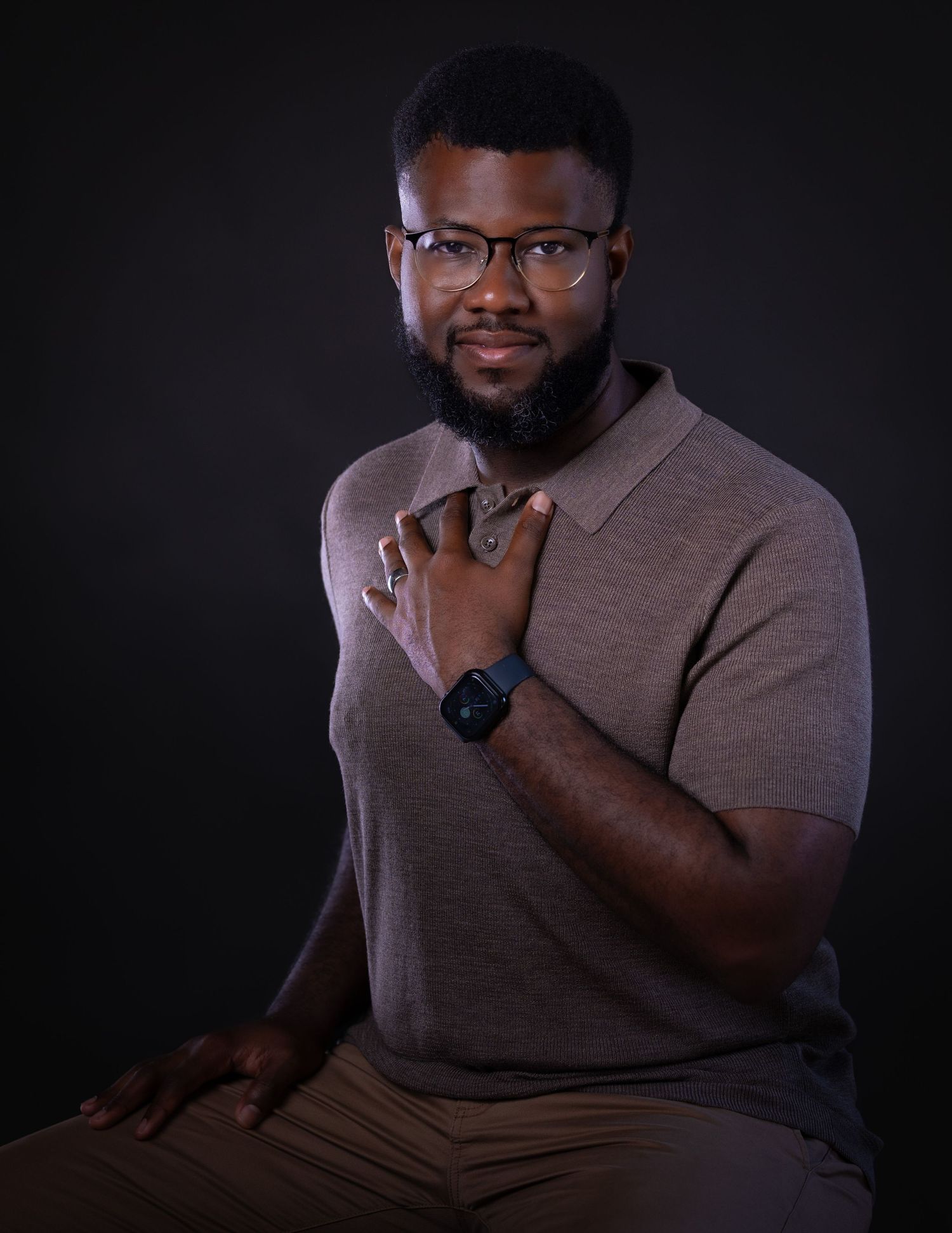 Person in gray polo shirt shown in dramatic low-key lighting against dark background in contemplative poses.