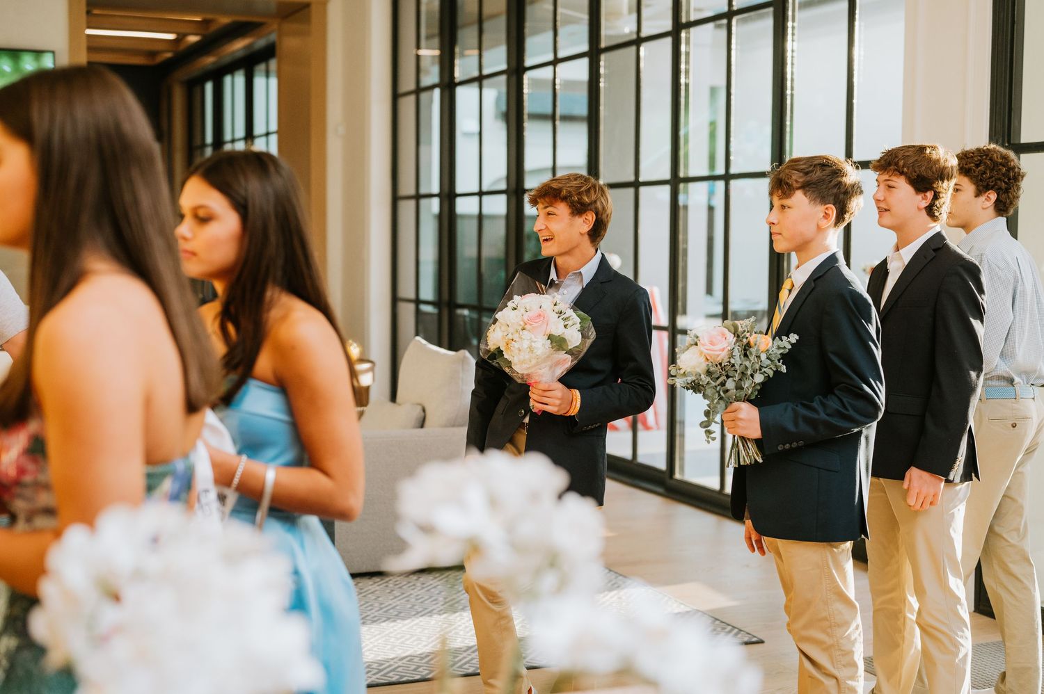 A group of people mingling and networking at an elegant indoor event with glass walls and modern decor.