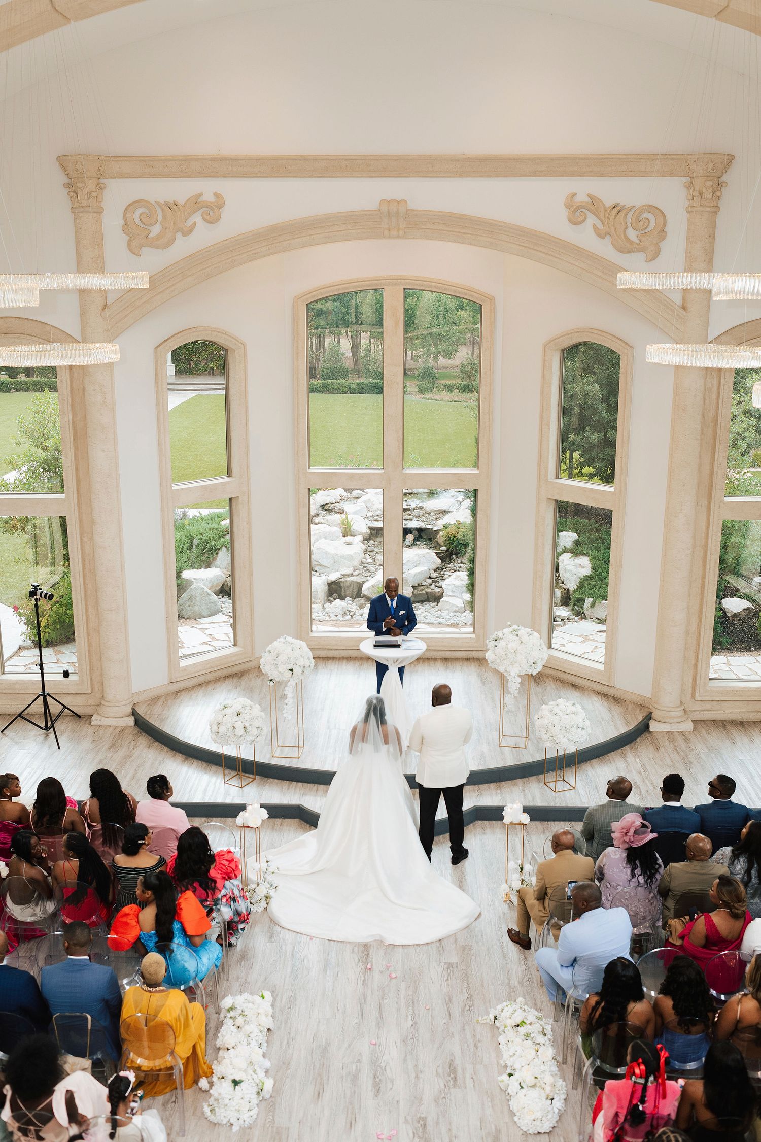 Wedding ceremony taking place in an elegant white gazebo surrounded by guests and beautiful outdoor scenery.